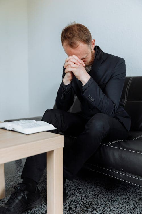 Business leader in prayer with Bible